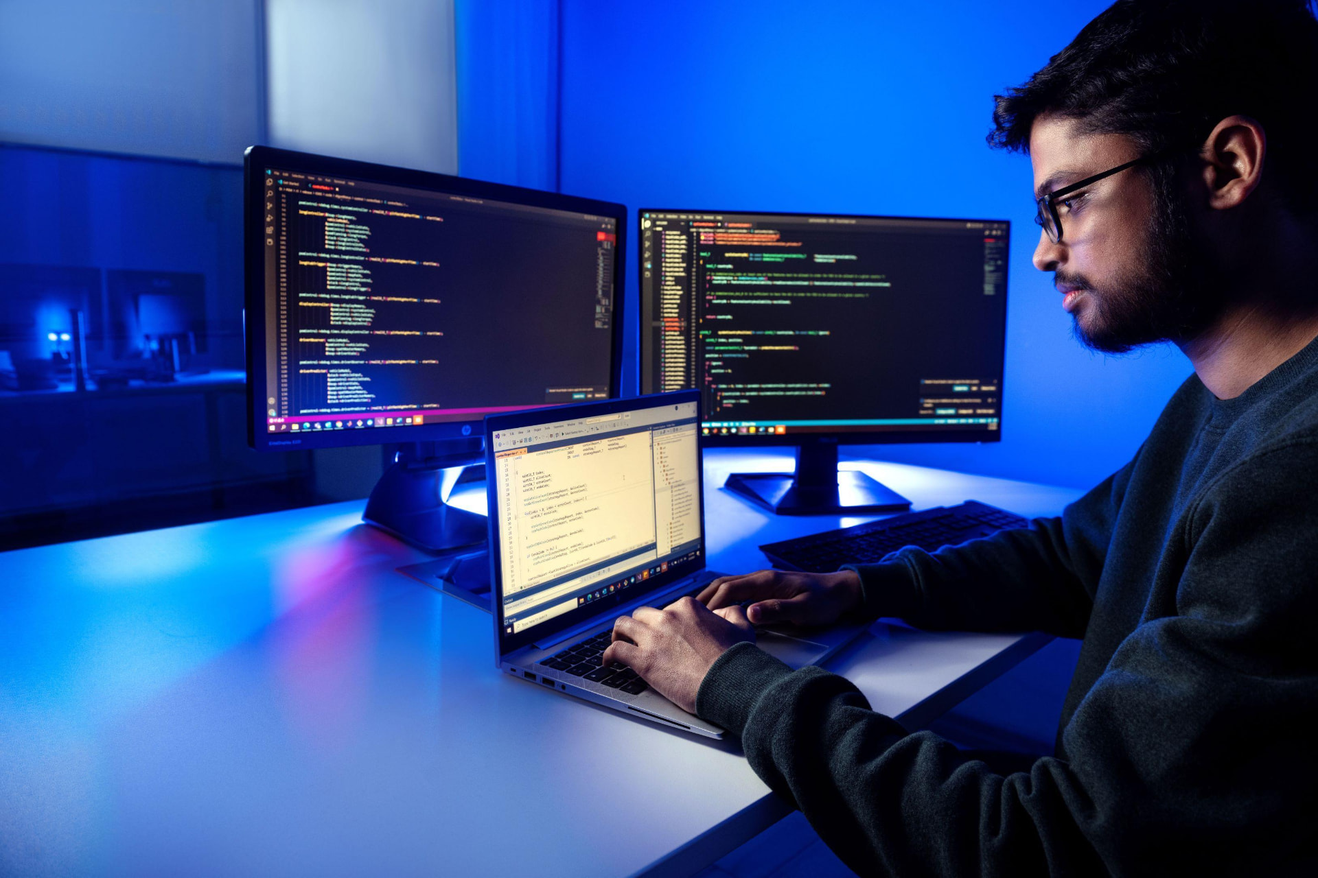 Mapsoft developer writing code across multiple screens